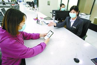  在東城區(qū)政務(wù)服務(wù)大廳，前來(lái)辦事的企業(yè)工作人員通過(guò)“北京通”授權(quán)電子證照應(yīng)用